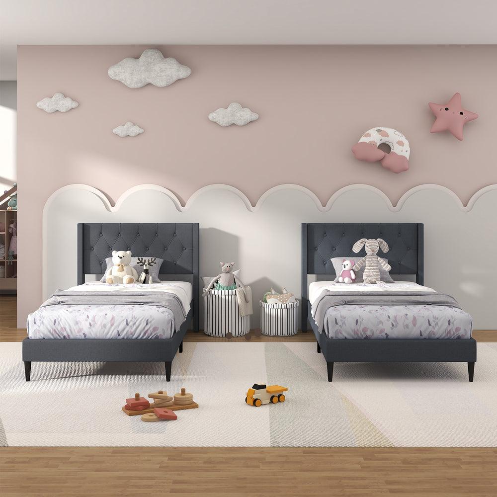 Twin size upholstered platform beds with button tufted gray headboards, perfect for children's bedrooms or guest rooms.