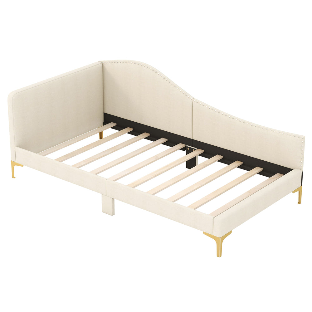 Upholstered twin size daybed with metal legs, wood slats, and rivet design, perfect for versatile use in any space.