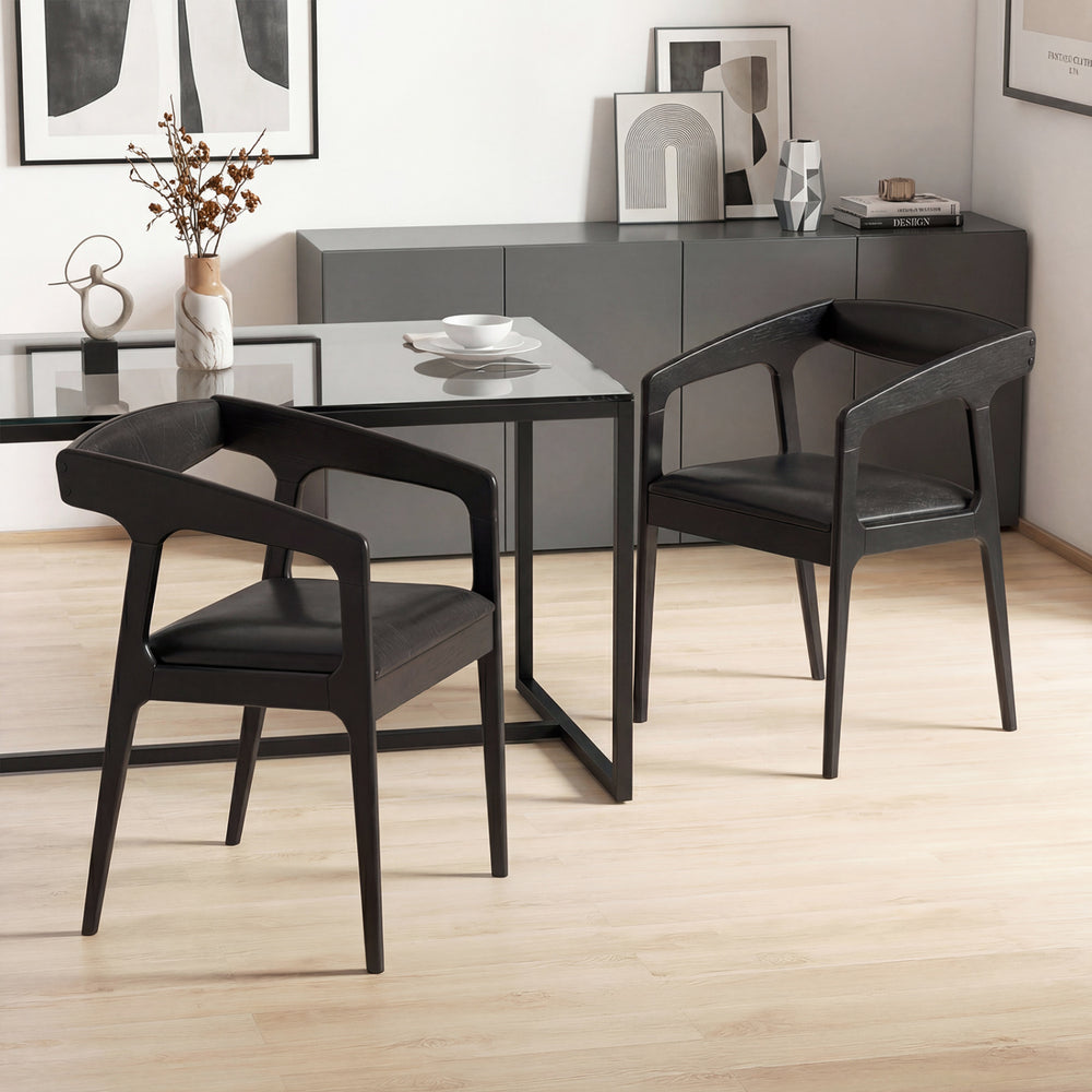 Set of 2 black upholstered armchairs with cozy backrest and padded seat, perfect for modern dining spaces.
