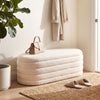 Upholstered fabric storage ottoman bench in white, showcasing a smooth, rounded design, perfect for entryways or.