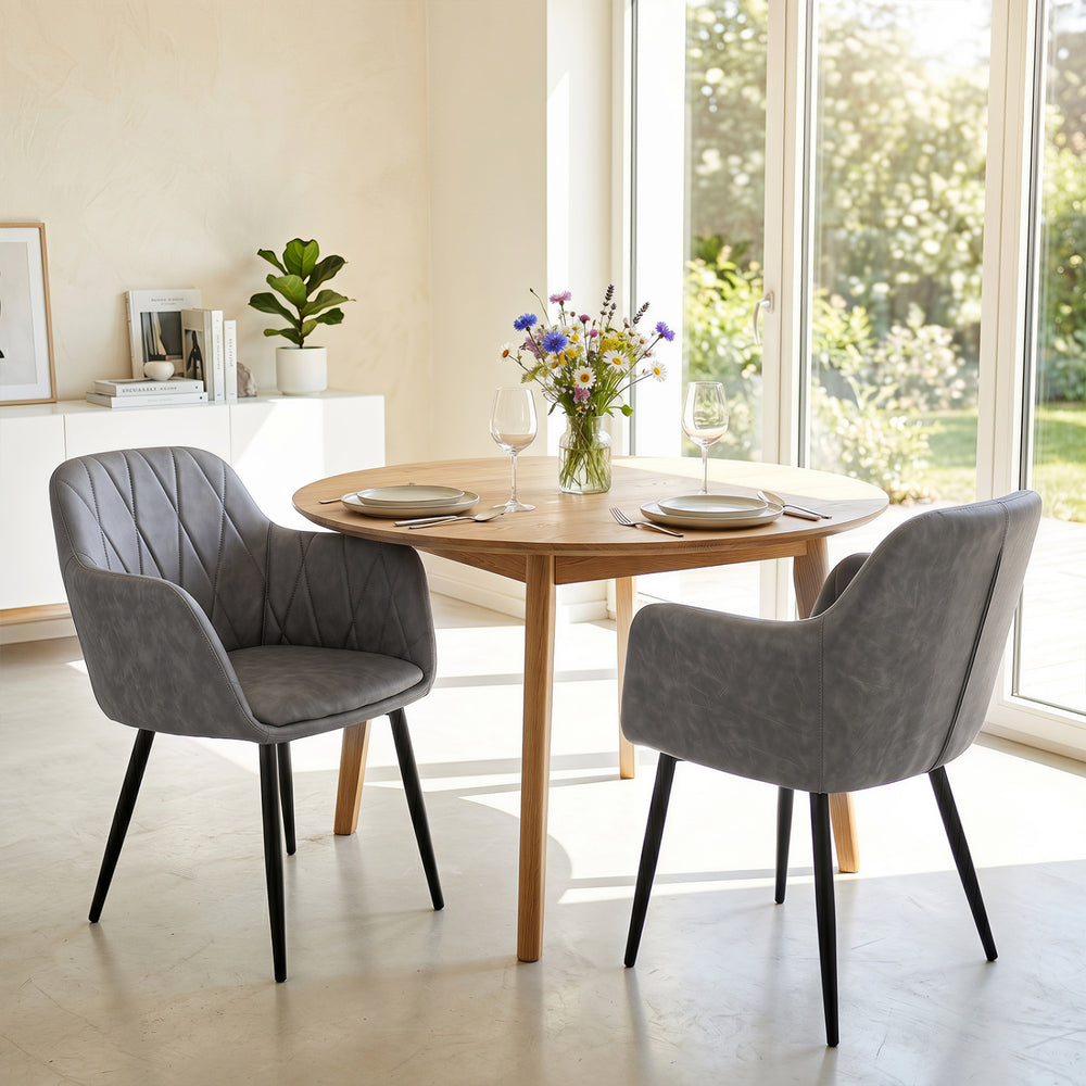 Gray upholstered PU leather kitchen chairs with curved back and wide seat, perfect for dining rooms and kitchens.