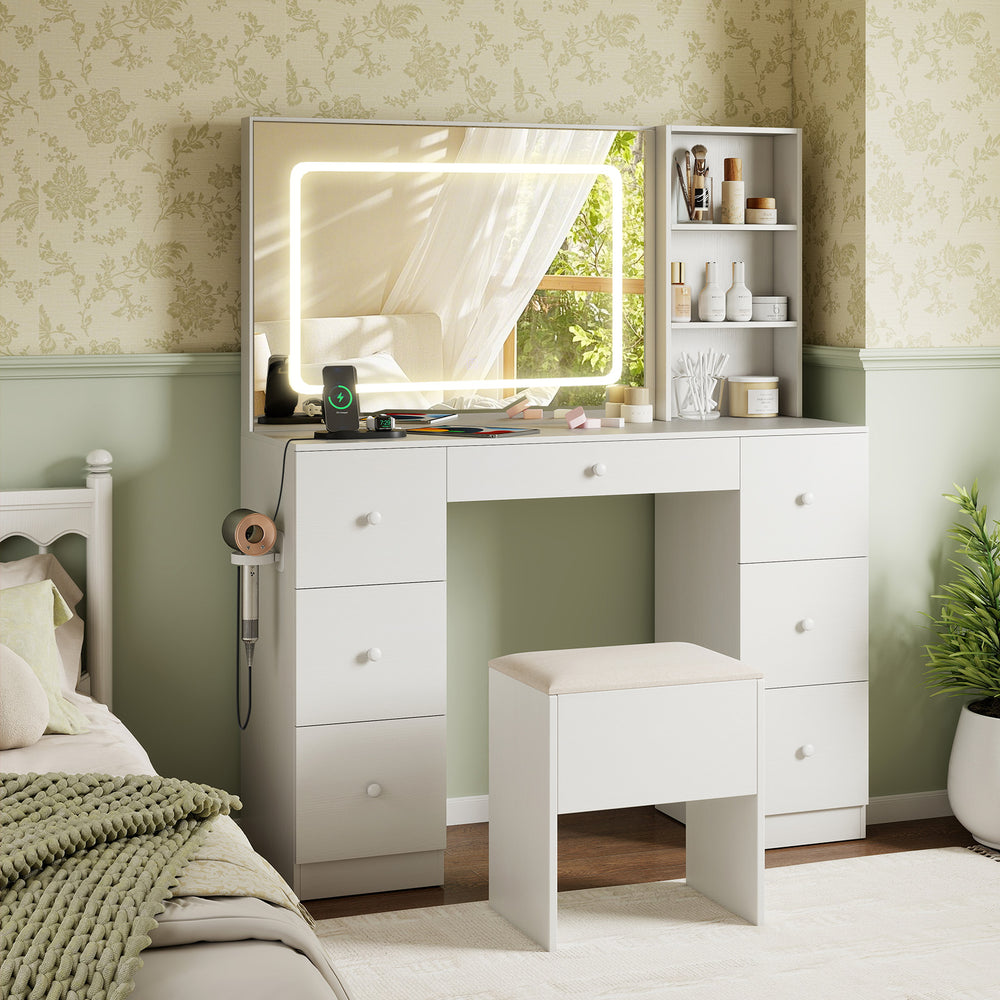 White vanity desk with lighted mirror, 3 open shelves, 7 drawers, and padded stool for makeup application.