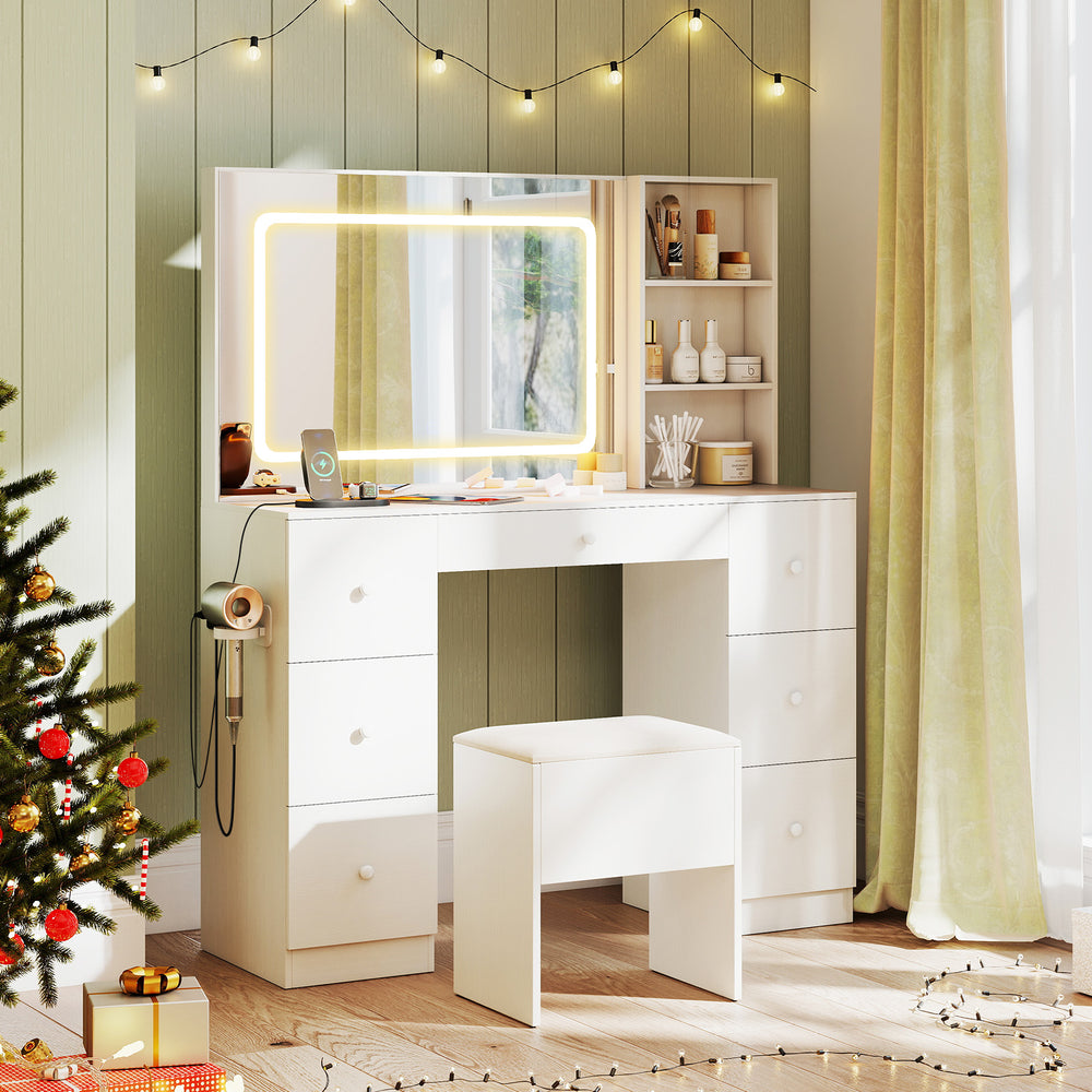 White vanity desk with lighted mirror, stool, ample storage, and built-in charging station for makeup application.