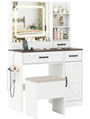 Vanity desk with lighted mirror, ample storage, and a stool, designed in white farmhouse style for makeup application.