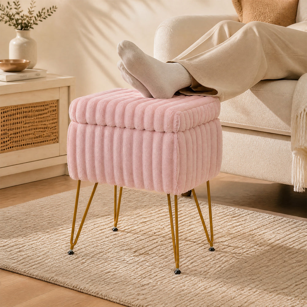 Plush pink vanity stool with storage and reversible lid, featuring sturdy metal legs, ideal for footrest or end table use.
