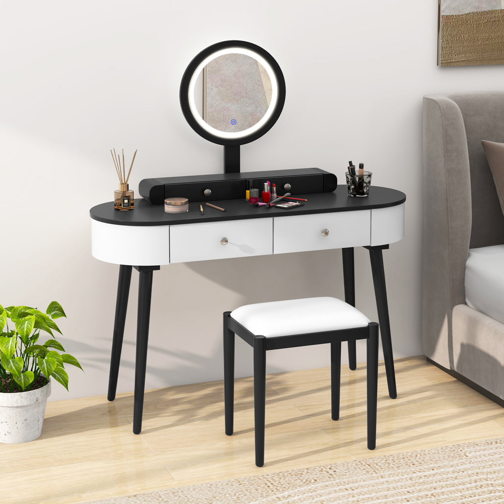 Makeup vanity table set showcasing the stylish black and white design with a round LED mirror and cushioned stool.