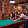 Side view of wall-mounted billiards pool cue rack in brown, made of solid pine wood, showcasing its compact design and.