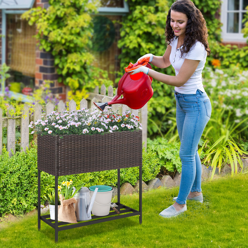 Wicker raised garden bed with removable liner and storage shelf, ideal for growing flowers and herbs in your garden.