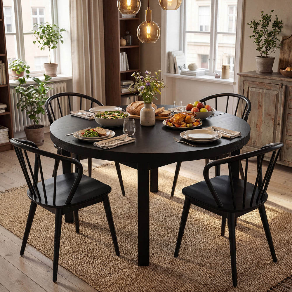 Black Windsor dining chairs set of 4 with spindle backrest, elegantly placed around a round dining table in a cozy.