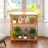Wood cold frame greenhouse with transparent roof and slatted storage shelf, ideal for prolonging vegetable growth.