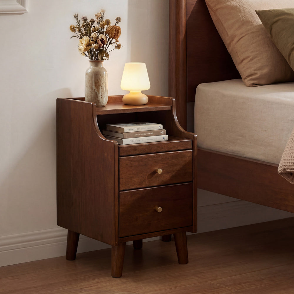 Wood nightstand in brown with two drawers and solid wood legs, perfect for bedroom storage beside a bed.