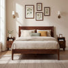 Brown wood nightstand with drawers and solid wood legs, styled beside a bed in a cozy bedroom setting.
