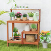 Outdoor garden potting workstation made of solid wood with open shelves, ideal for plant care on patio or backyard.