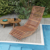 Outdoor acacia wood rocking chair with widened slatted seat, shown by the poolside for ultimate relaxation.