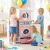 Wooden kids laundry playset in pink with washing machines, detergent bottle, and clothes hangers for imaginative play.