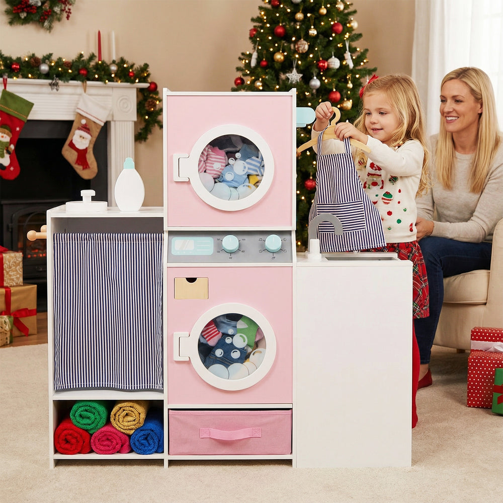 Wooden kids laundry playset in pink with washing machines, detergent bottle, and fabric storage for imaginative play.