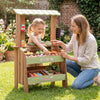 Wooden grocery store toy with accessories, featuring a child and parent engaging in pretend play for social skill.