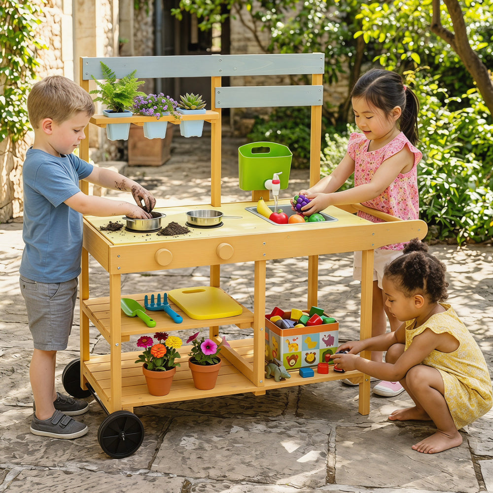 Wooden outdoor mud kitchen for kids in yellow with stoves, sink, flowerpots, and wheels for fun outdoor play.