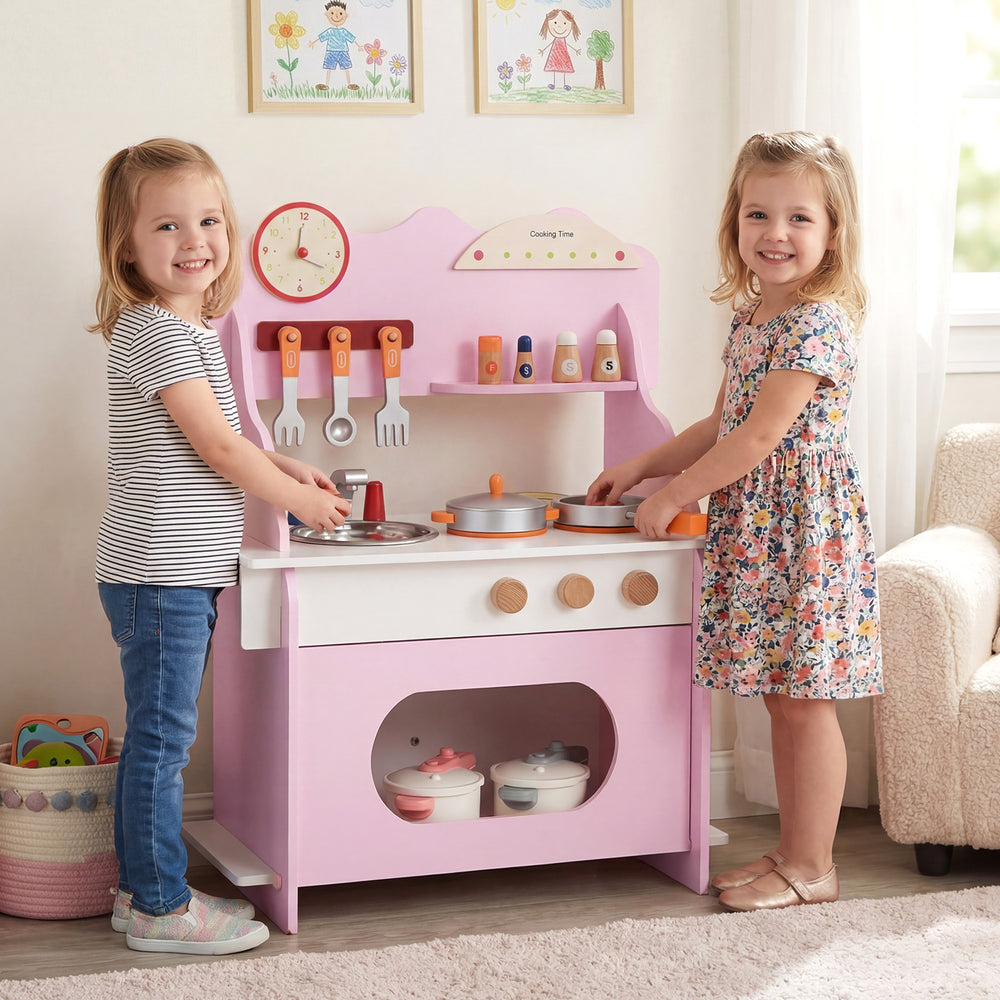 Wooden play kitchen in pink with accessories, featuring a clock, for kids' pretend play and imaginative learning.