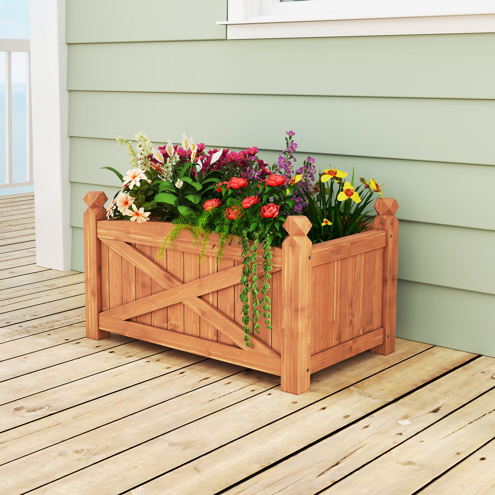 Wooden raised garden bed made of solid fir wood with drainage holes, showcasing vibrant flowers on a patio.