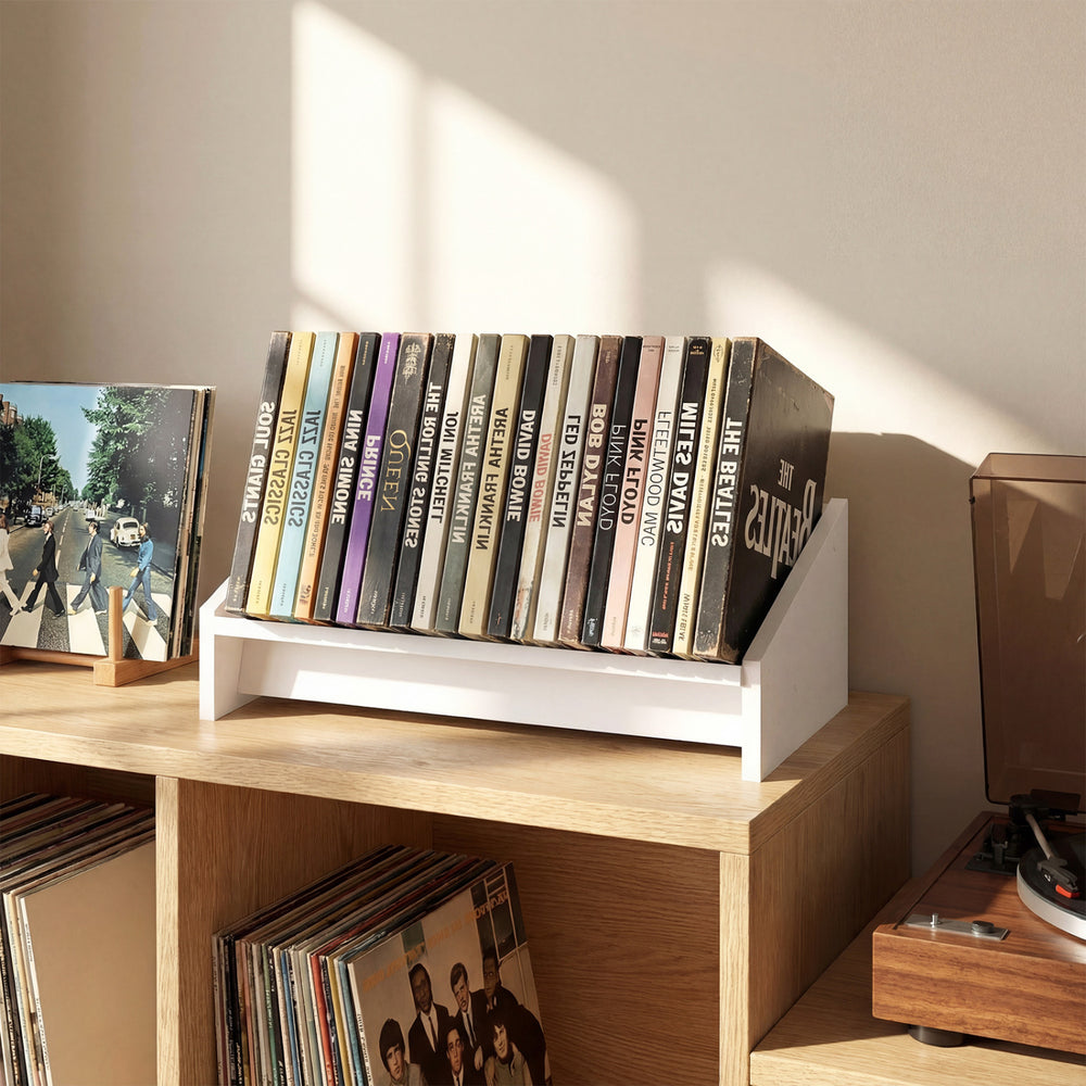 White wooden tilting bookshelf organizer displaying vinyl records, ideal for desktop use in living rooms or studies.