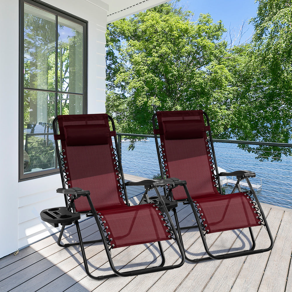 Two dark red outdoor folding zero gravity reclining lounge chairs on a porch, perfect for relaxation and entertainment.