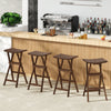 Set of two teak wood bar stools with saddle seats and footrests, perfect for kitchen islands or balconies.
