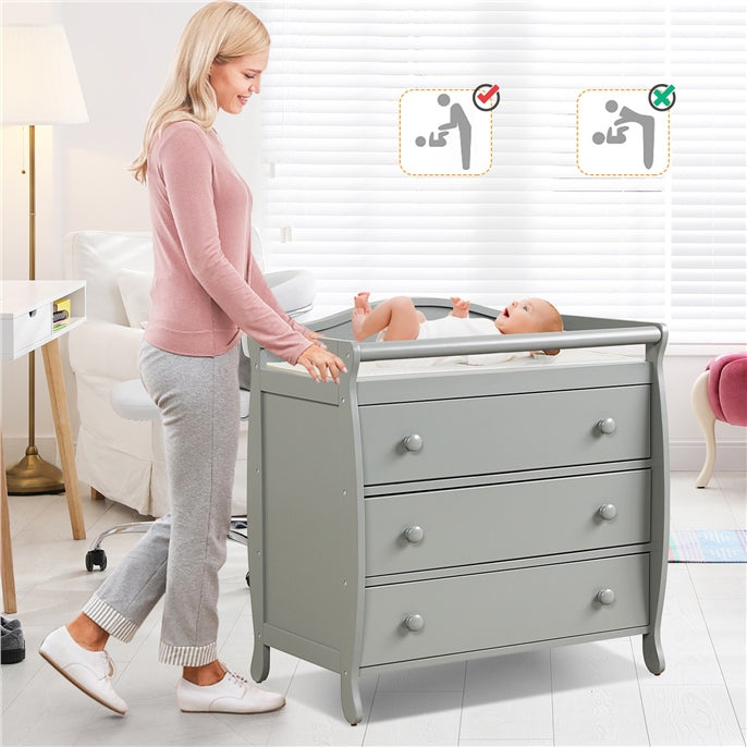 Gray baby changing table with three drawers and safety belt, designed for convenience and stability during diaper.