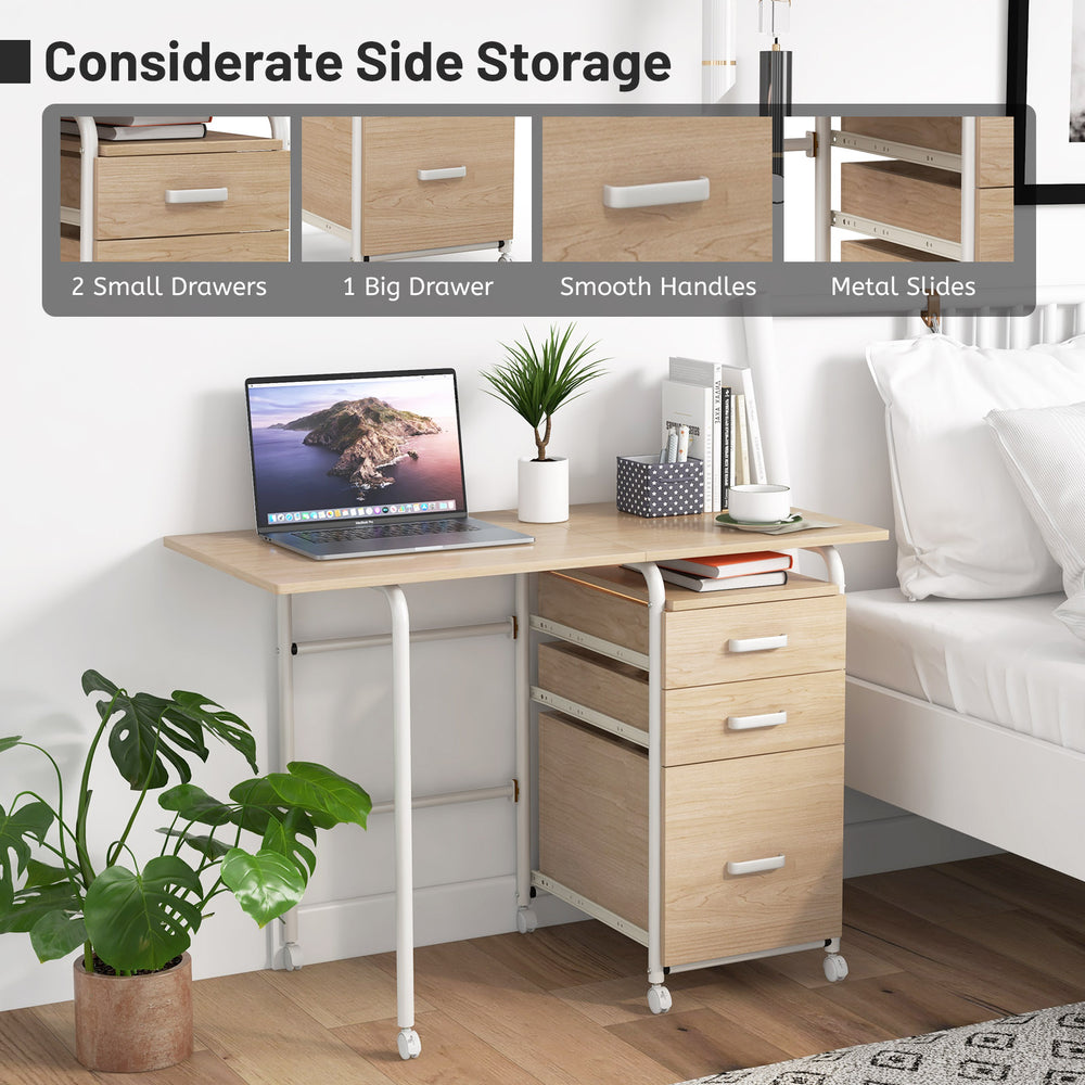 Folding computer desk with three drawers, natural finish, and wheels for easy mobility, ideal for small spaces.