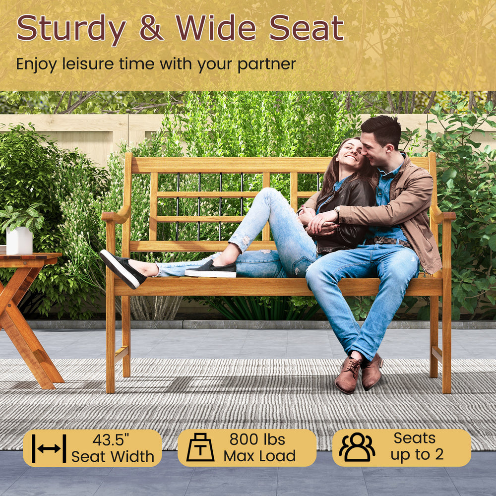 Acacia wood patio bench with curved armrests, slatted seat, and backrest, seats 2, ideal for backyard relaxation.
