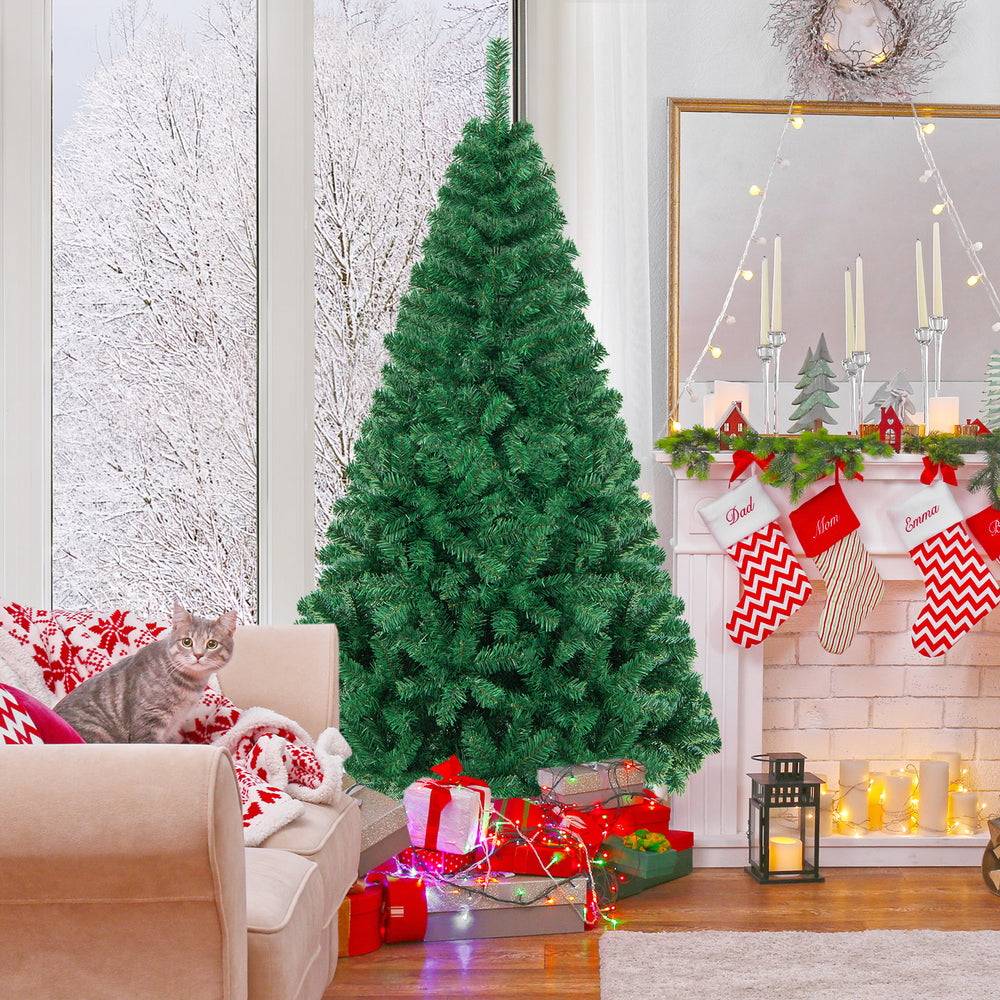 Artificial PVC Christmas tree with solid metal stand, elegantly set in a cozy living room, surrounded by festive decor.