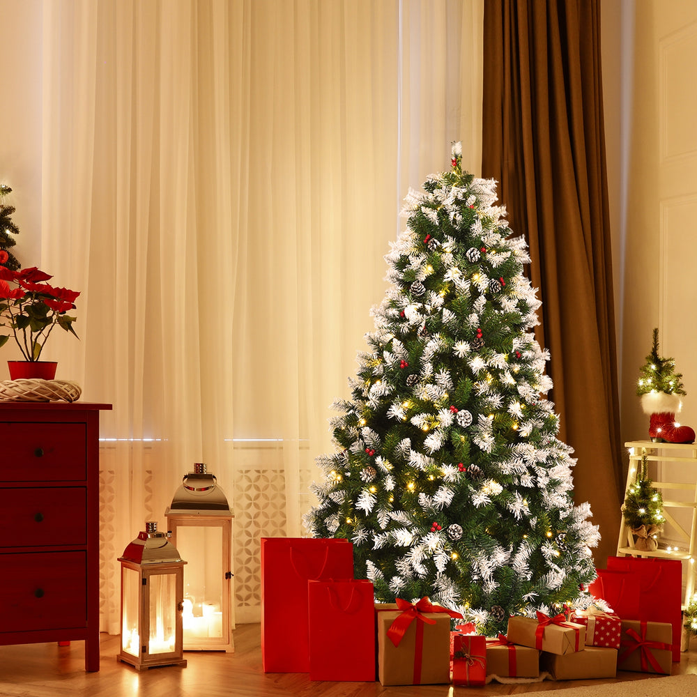 Snow flocked 6 ft Christmas tree with red berries and 250 LED lights, perfect for festive home decoration.