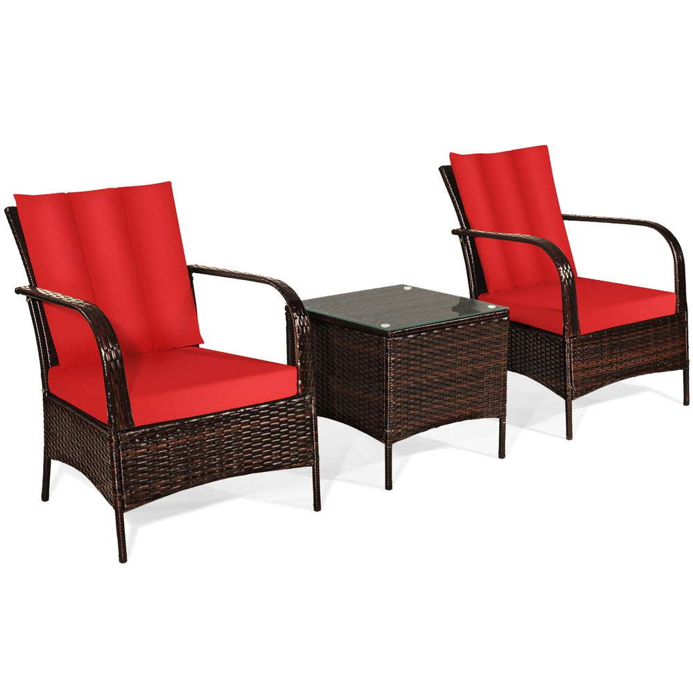 Two red cushioned rattan chairs with a glass top coffee table, perfect for outdoor patio relaxation.
