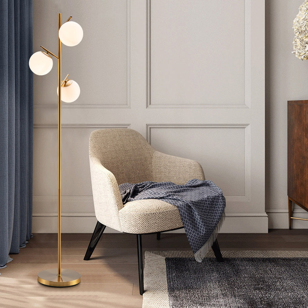 Three-globe floor lamp with golden finish, featuring a sturdy steel pole and glass lampshades, perfect for stylish.