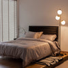 Three-globe floor lamp with golden accents, featuring a foot switch, stylish design, and sturdy steel base for.
