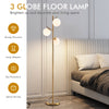 Three-globe floor lamp in gold with glass shades, foot switch, and slim design for stylish corner lighting.