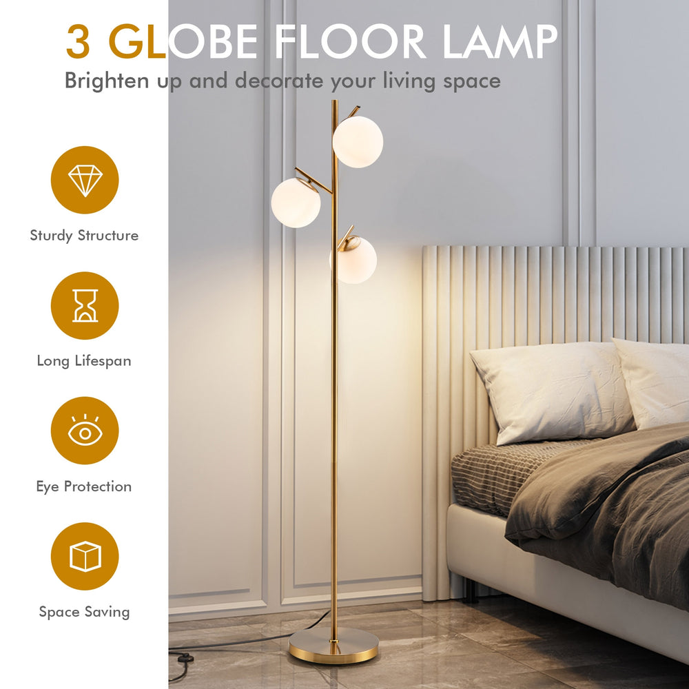 Three-globe floor lamp in gold with glass shades, foot switch, and slim design for stylish corner lighting.