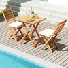 Folding chair table set with soft seat cushions in natural acacia wood, perfect for poolside relaxation.
