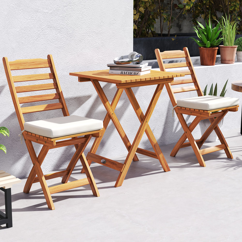 Folding chair table set featuring acacia wood, soft seat cushions, and slatted design, ideal for balcony or poolside.
