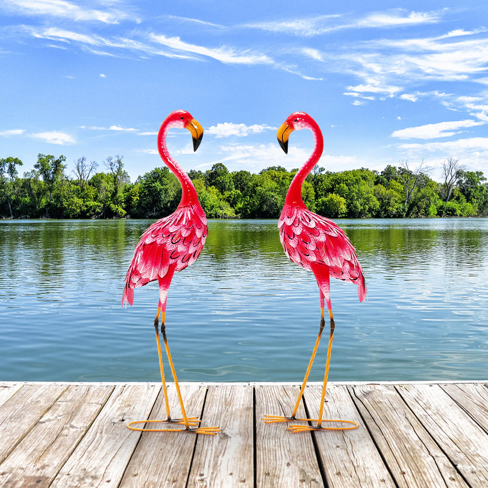 Two pink flamingo garden statues made of rustproof metal, perfect for charming backyard or lakeside decoration.