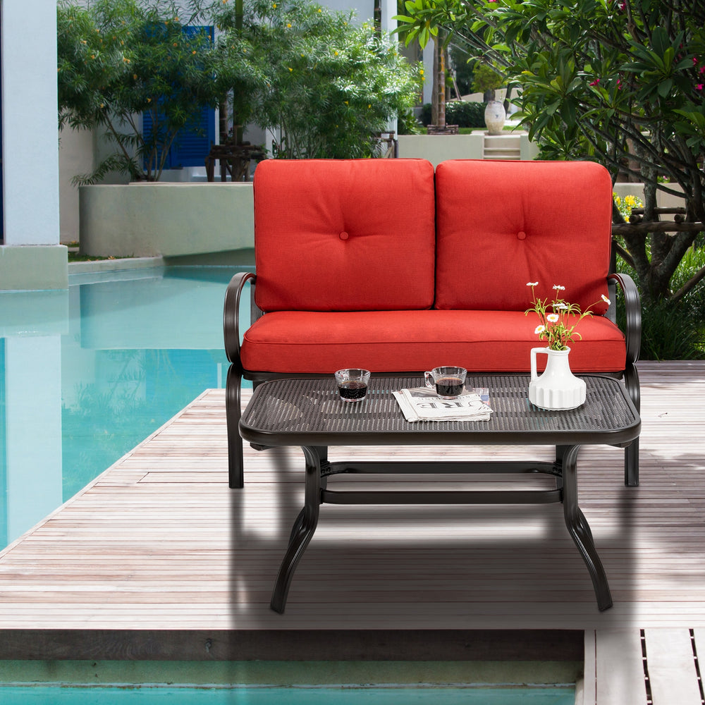 Loveseat with red cushions and coffee table, made of durable steel, perfect for patio or poolside relaxation.