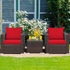 Patio conversation set featuring two red-cushioned rattan chairs and a glass-top table, perfect for outdoor relaxation.