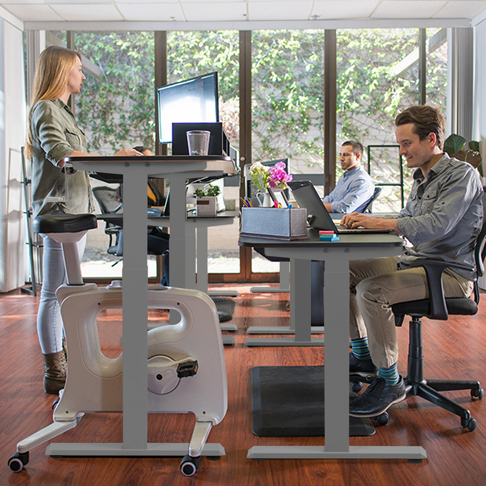 Height adjustable gray sit to stand desk frame with hand crank, suitable for various working postures in an office.