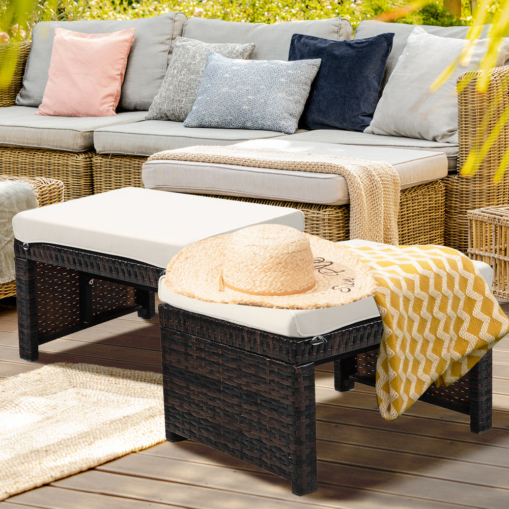 Patio rattan ottomans with soft white cushions, featuring a durable X-frame design for outdoor use and comfort.