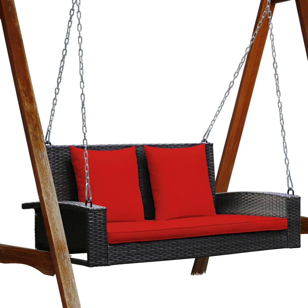 Rattan porch swing with red cushions, designed for two, featuring sturdy steel chains for outdoor relaxation.