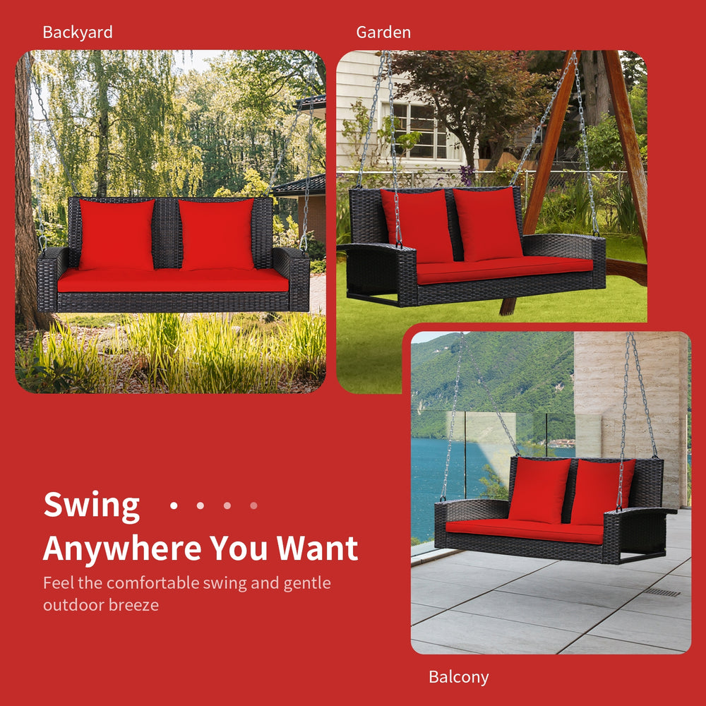 2-person patio rattan swing with red cushions, featuring sturdy steel chains for safe outdoor relaxation.
