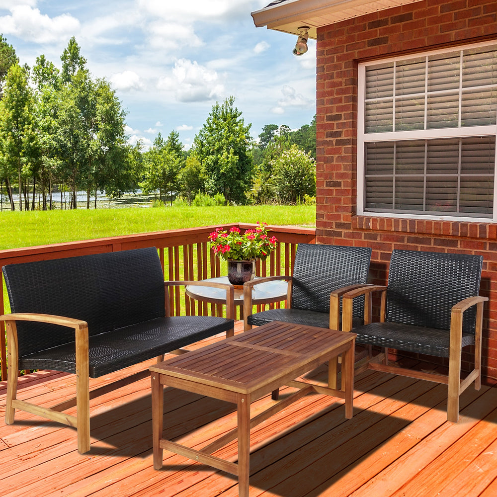 4-piece PE rattan patio furniture set with solid acacia wood, featuring a loveseat, two chairs, and a coffee table for.