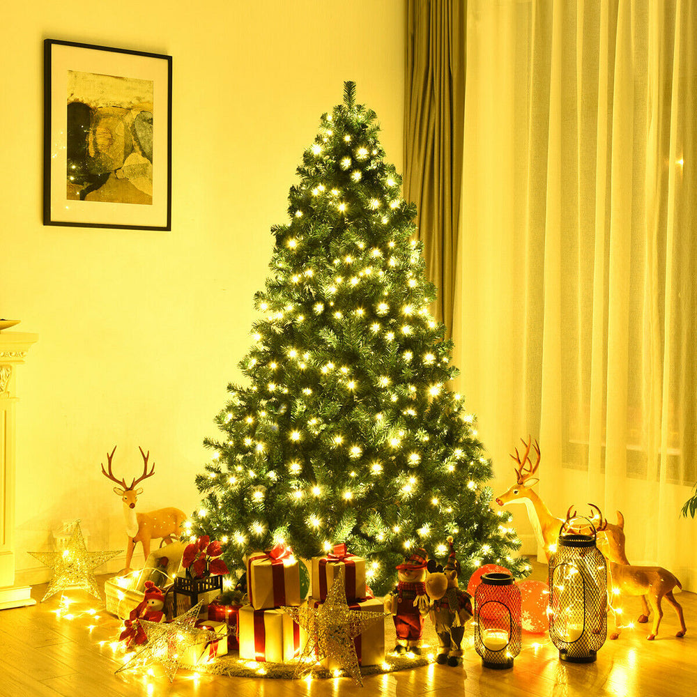7-foot PVC artificial Christmas tree with warm white LED lights, surrounded by gifts and festive decorations for indoor.