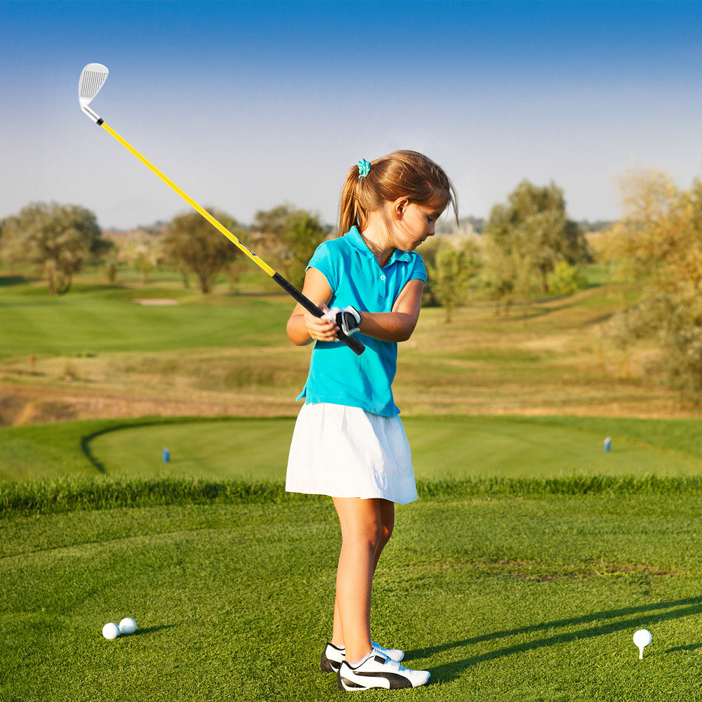 Young girl practicing her swing with a yellow individual golf club featuring a fiberglass shaft, ideal for kids aged.
