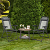 Two gray adjustable folding recliner chairs with a round coffee table, perfect for outdoor relaxation in a garden.